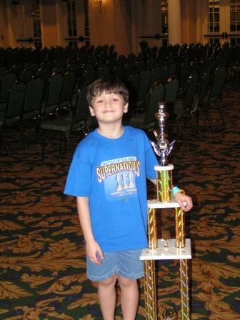 Mike in third grade at SuperNationals, standing beside his trophy